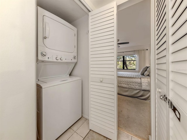 laundry room with light tile patterned floors and stacked washer and clothes dryer