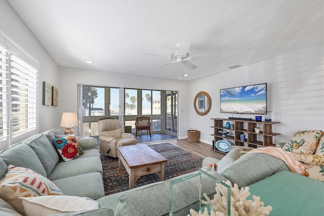 living room with wood-type flooring and ceiling fan