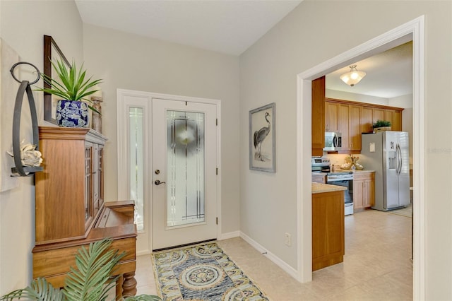 entryway featuring light tile patterned floors and baseboards