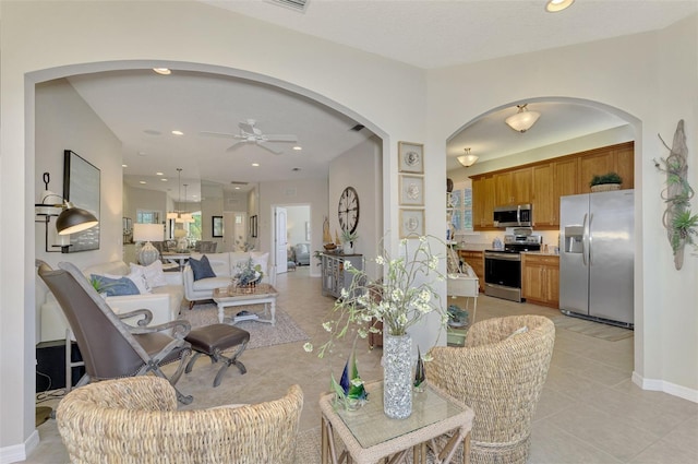 living area with a ceiling fan, recessed lighting, baseboards, and light tile patterned floors