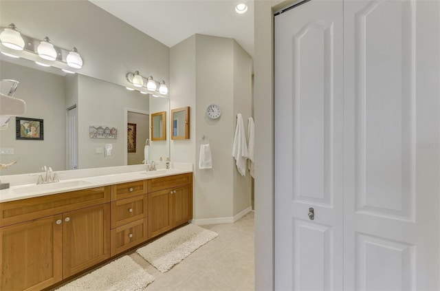 bathroom featuring double vanity, a closet, a sink, and tile patterned floors