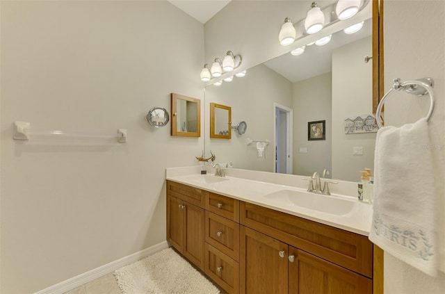 full bath featuring tile patterned flooring, a sink, baseboards, and double vanity