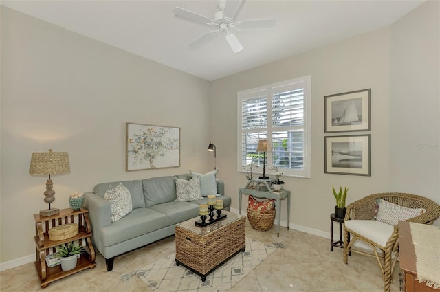 living area featuring a ceiling fan and baseboards