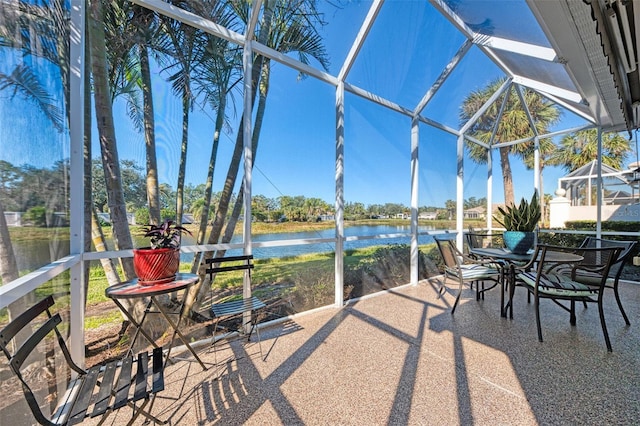 sunroom featuring a water view