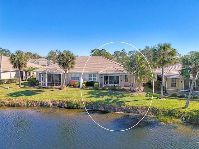 exterior space featuring a tile roof, a lanai, a water view, and a yard