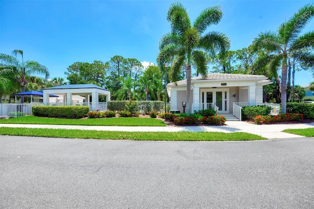 view of front of house with a fenced front yard, french doors, and stucco siding