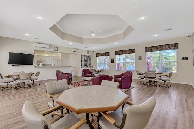 living room with visible vents, a raised ceiling, crown molding, and a wall mounted AC