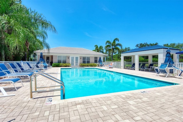 pool with a gazebo, fence, and a patio