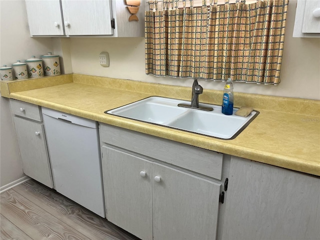 kitchen featuring sink, dishwasher, and hardwood / wood-style flooring