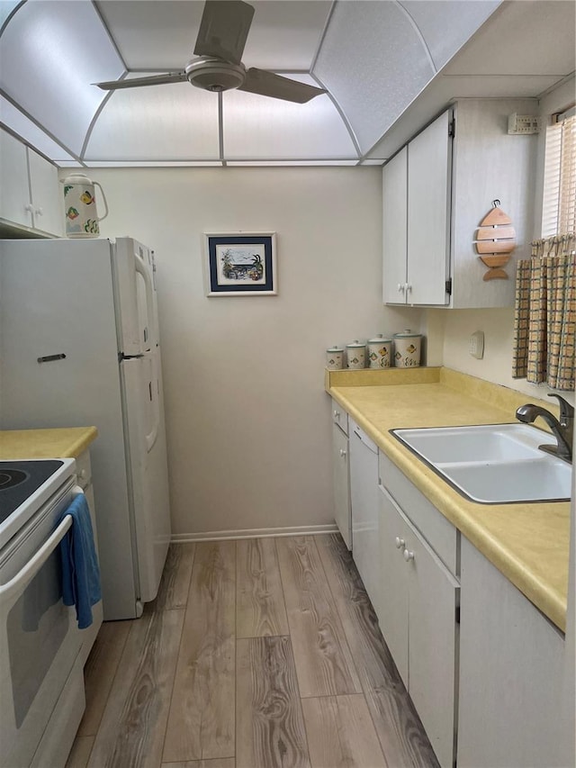 kitchen featuring white appliances, white cabinetry, light wood-type flooring, and sink