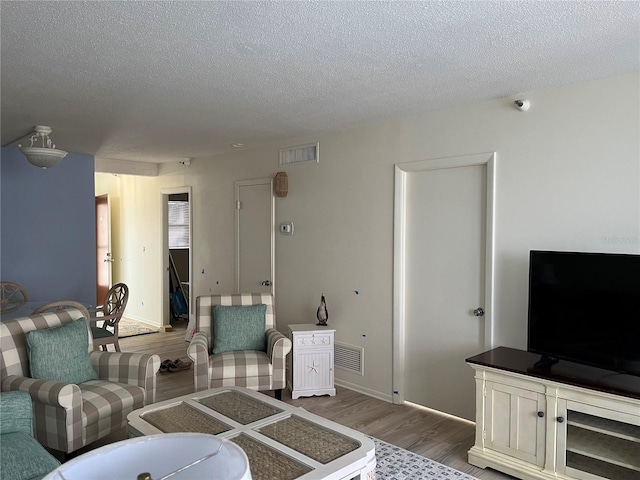 living room with hardwood / wood-style flooring and a textured ceiling