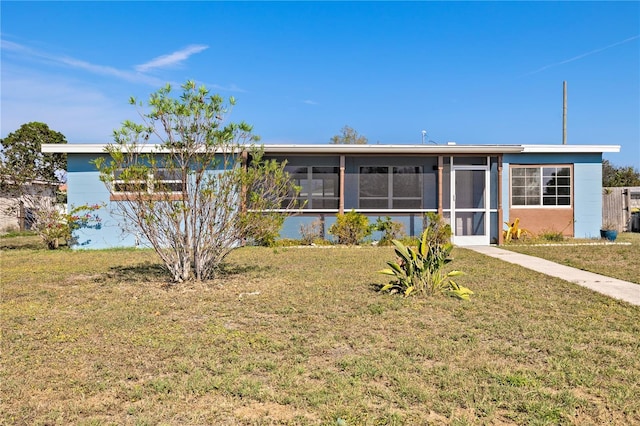 exterior space with a front lawn and a sunroom