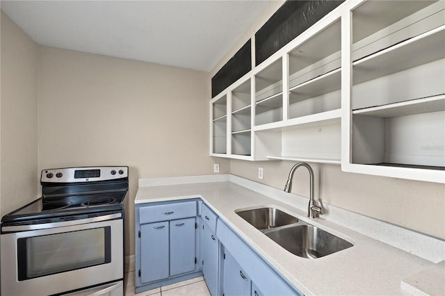 kitchen featuring blue cabinetry, light tile patterned flooring, sink, and stainless steel range with electric cooktop