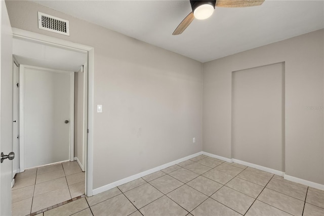 spare room with ceiling fan and light tile patterned floors