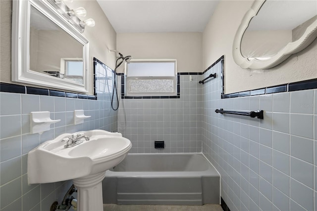 bathroom featuring tiled shower / bath combo and tile walls