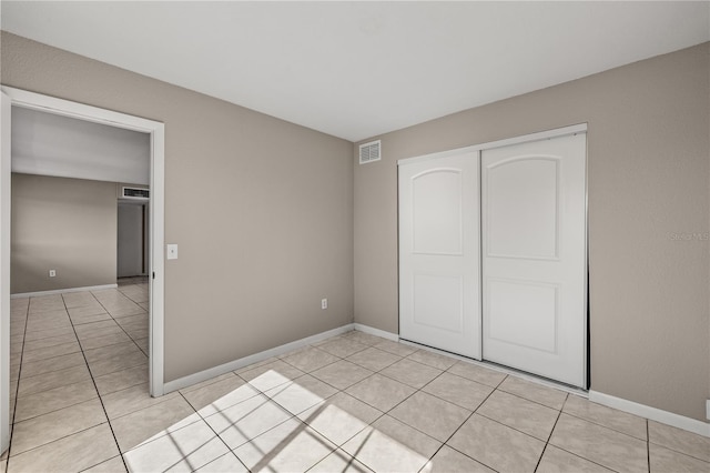 unfurnished bedroom with light tile patterned floors and a closet