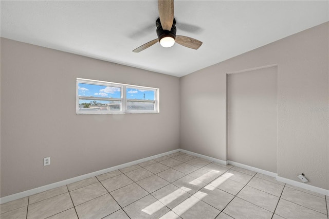 spare room with light tile patterned floors, vaulted ceiling, and ceiling fan