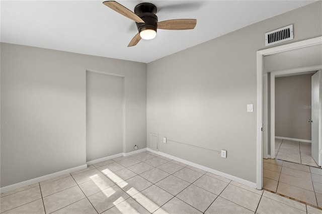 tiled empty room with ceiling fan