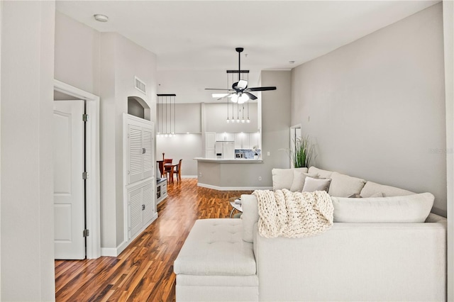 living room featuring ceiling fan and dark wood-type flooring