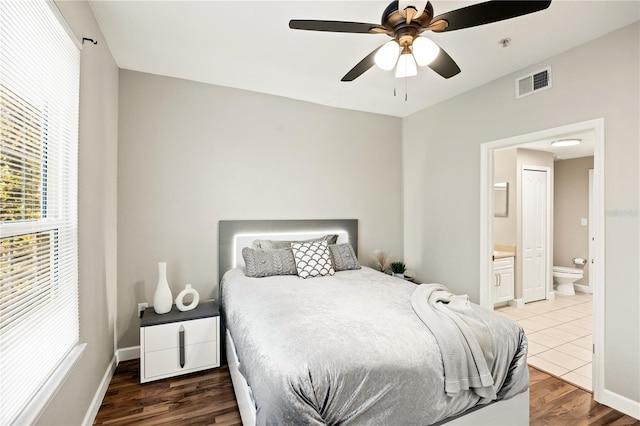 bedroom featuring ensuite bath, ceiling fan, and dark wood-type flooring