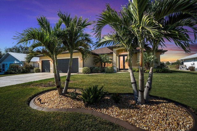 view of front of home featuring a garage and a yard