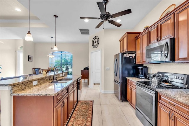 kitchen featuring stainless steel appliances, sink, hanging light fixtures, a kitchen island with sink, and light tile patterned floors