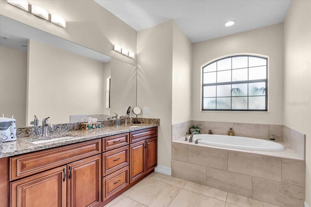 bathroom featuring vanity, tiled bath, and tile patterned flooring