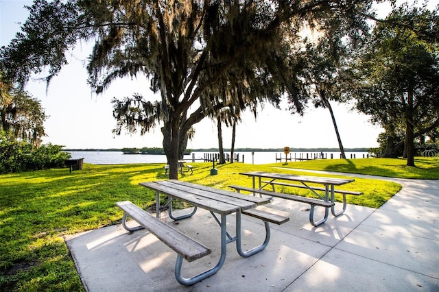 surrounding community featuring a lawn and a water view