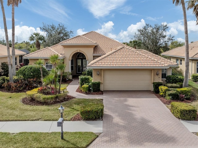 mediterranean / spanish-style house featuring a garage and a front yard