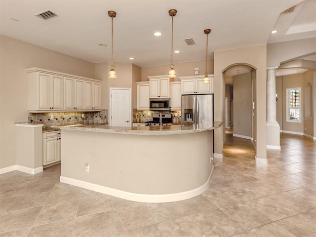 kitchen with a spacious island, stainless steel appliances, decorative light fixtures, and decorative columns