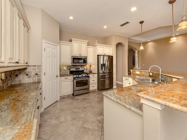 kitchen with decorative light fixtures, sink, decorative backsplash, stainless steel appliances, and light stone countertops