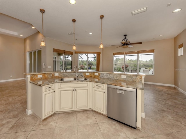 kitchen with stainless steel dishwasher, sink, light stone countertops, and a kitchen island with sink