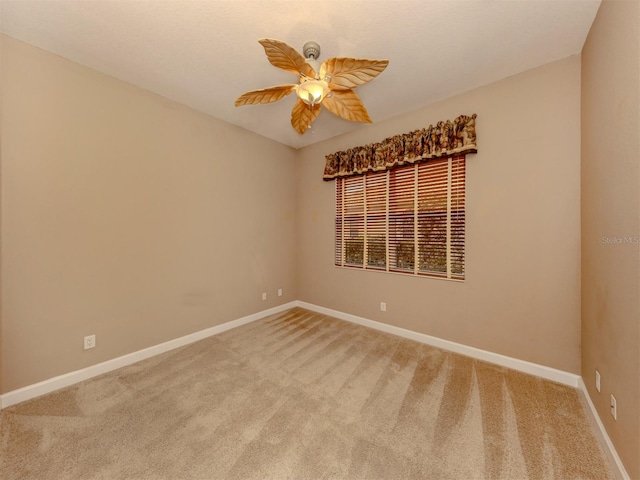 carpeted spare room featuring ceiling fan