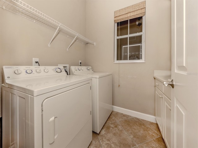 clothes washing area featuring separate washer and dryer and cabinets