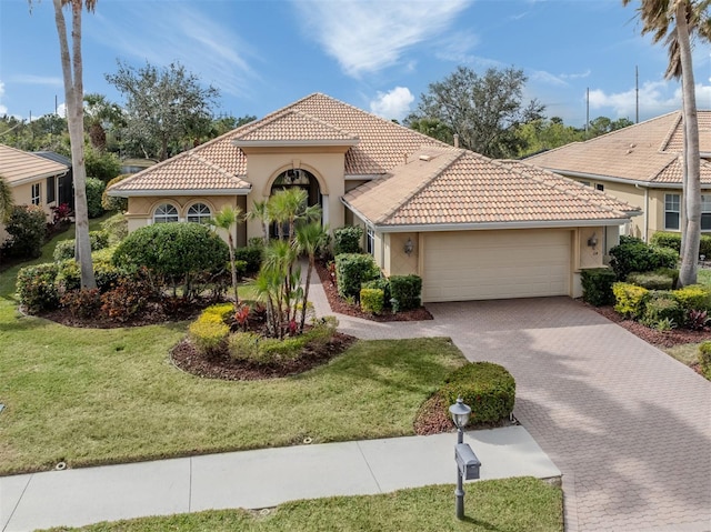 mediterranean / spanish house with a garage and a front lawn