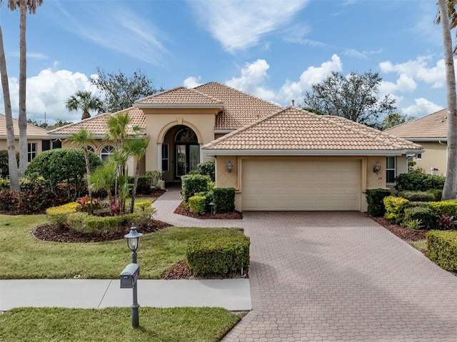 mediterranean / spanish-style house with a garage and a front yard