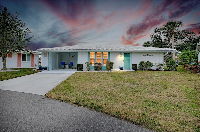 ranch-style house featuring a carport and a lawn