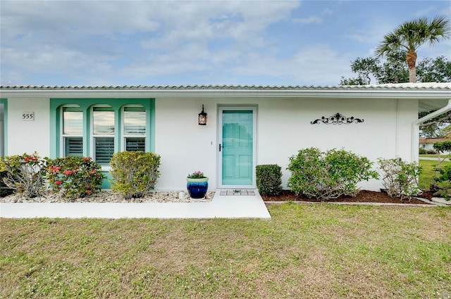 doorway to property with a lawn