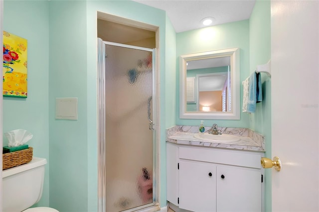 bathroom with vanity, a shower with shower door, a textured ceiling, and toilet