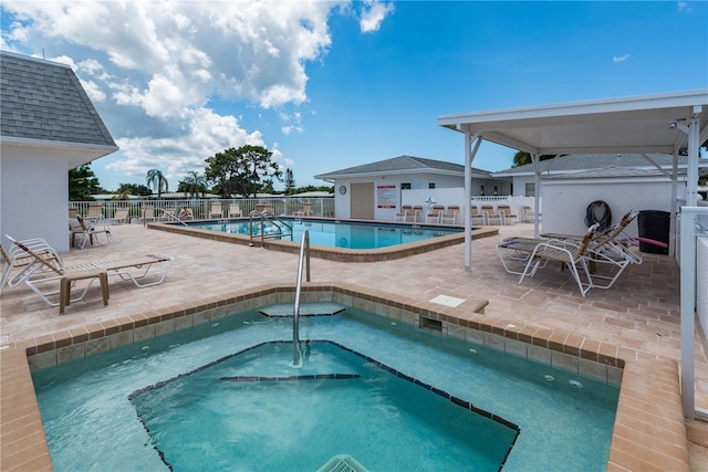 view of swimming pool with a patio area and a hot tub