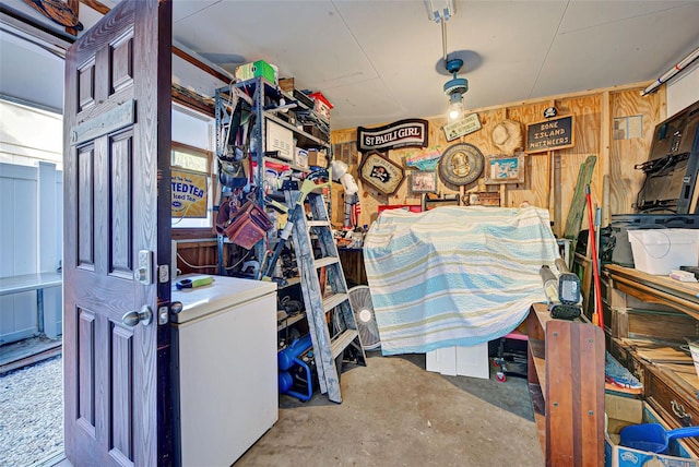 garage featuring wood walls and fridge