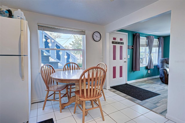 dining space with plenty of natural light and light tile patterned flooring