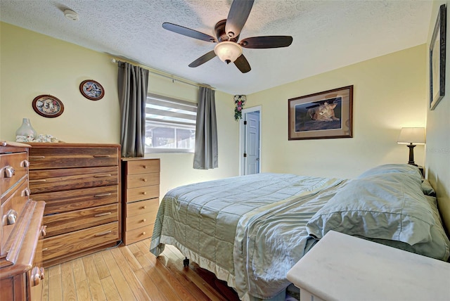 bedroom with wood-type flooring, a textured ceiling, and ceiling fan