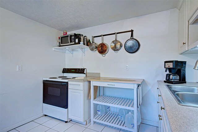 kitchen featuring sink, white electric stove, a textured ceiling, light tile patterned flooring, and white cabinetry