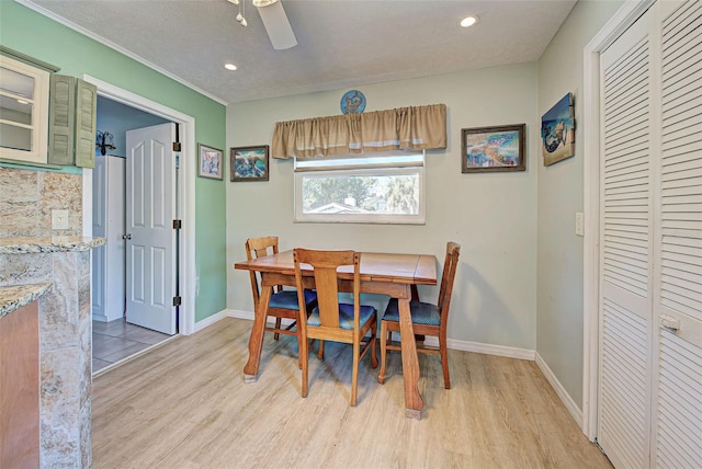 dining space with ceiling fan, a textured ceiling, and light wood-type flooring