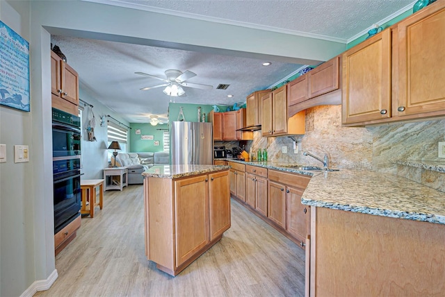 kitchen featuring sink, a kitchen island, black appliances, and a textured ceiling