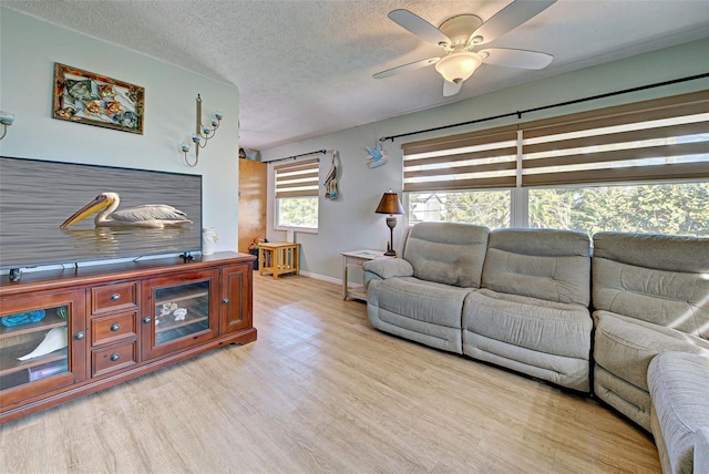 living room featuring a wealth of natural light, ceiling fan, light hardwood / wood-style floors, and a textured ceiling