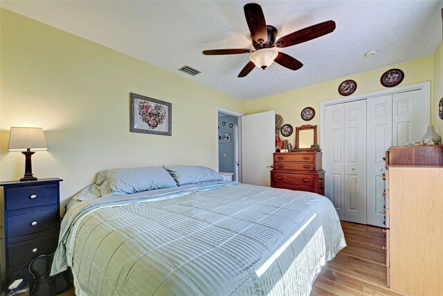 bedroom with light wood-type flooring, a closet, and ceiling fan