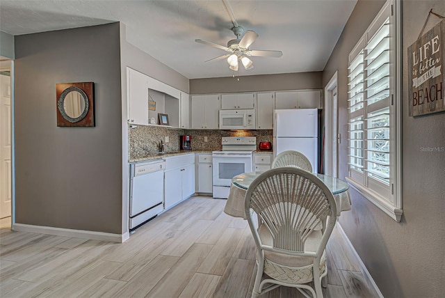 kitchen with light wood-type flooring, backsplash, white appliances, sink, and white cabinetry