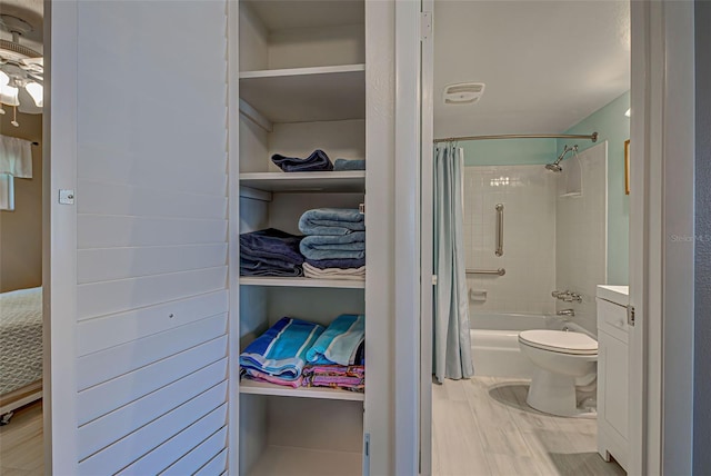 full bathroom featuring vanity, hardwood / wood-style flooring, toilet, and shower / bathtub combination with curtain